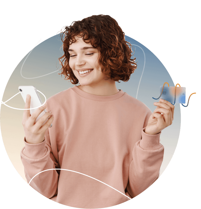 Smiling woman looking at her smartphone while holding a credit card