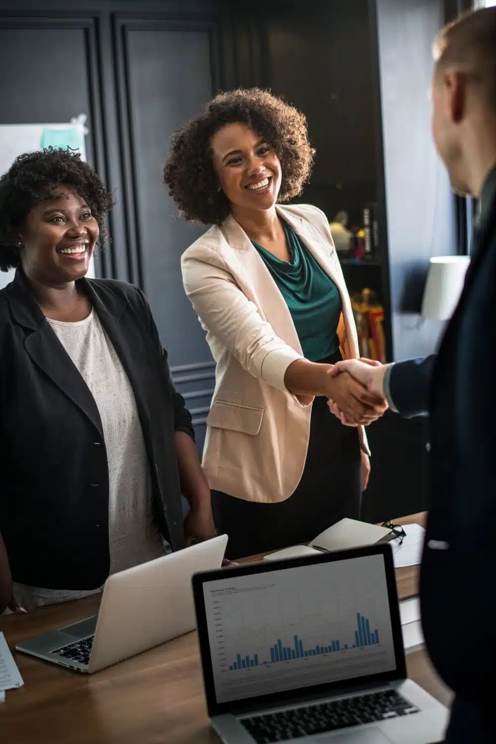 Businesswomen closing deal with handshake in office meeting