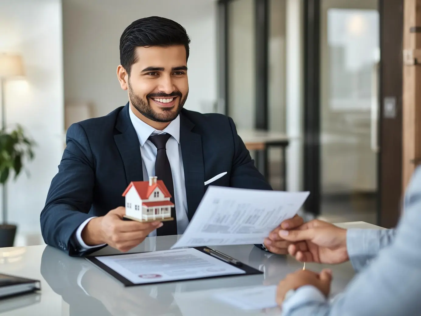 Real estate agents offer contracts to buy or rent housing. Businessman holding model small building house with property insurance at table in home sales office