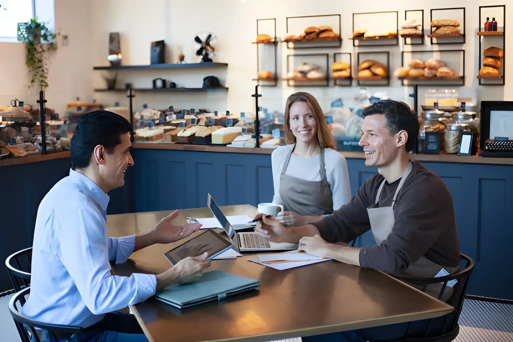 mature man owner staff employee sitting together in small business bakery